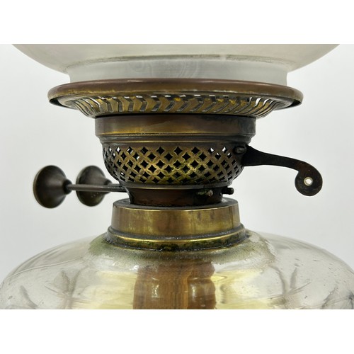 1130 - Two brass oil lamps. Lamp with shade approx. 60cm h.