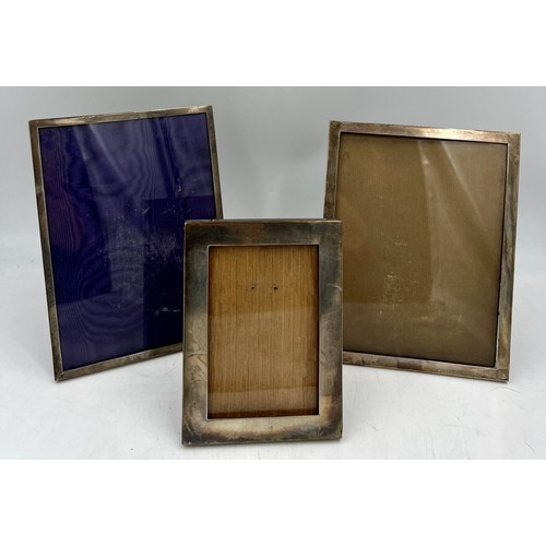 885 - Three hallmarked silver photograph frames.  17cm x 12.5 cm, Birmingham 1916, 22.5cm x 17.5cm Birming... 