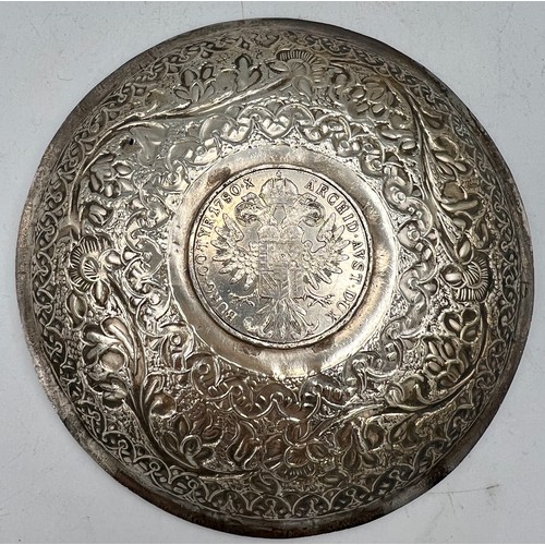 889 - A white metal saucer dish with an Austrian Marie Theresa Thaler to centre. 13cm d. Weight 108gm.