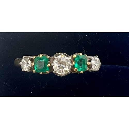 679 - An unmarked yellow and white metal ring set with green and clear stones. Size Q. Weight 2.7gm.