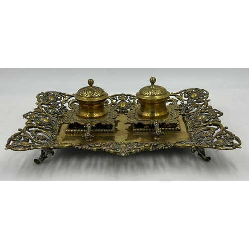 1074 - An ornate early 20thC brass double inkwell with pen stand. 34 x 27cm.