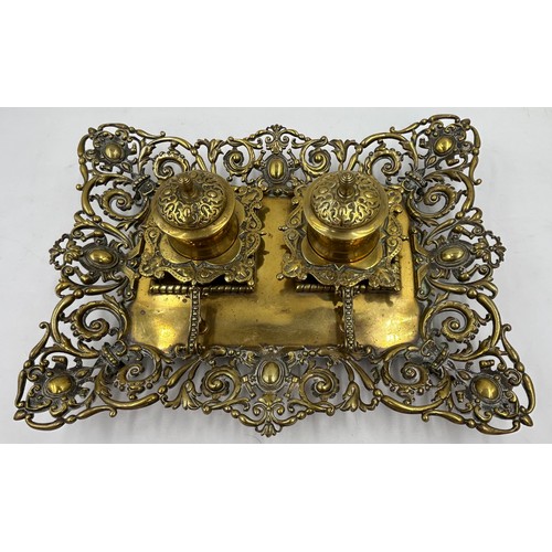 1074 - An ornate early 20thC brass double inkwell with pen stand. 34 x 27cm.