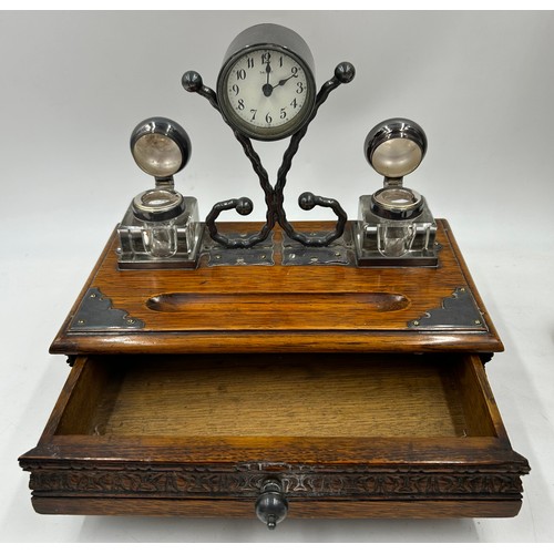 1389 - An oak desk stand with two glass inkwells,  pen trough,  drawer to front and Salvest clock to centre... 