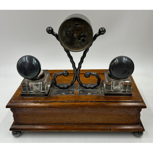 1389 - An oak desk stand with two glass inkwells,  pen trough,  drawer to front and Salvest clock to centre... 