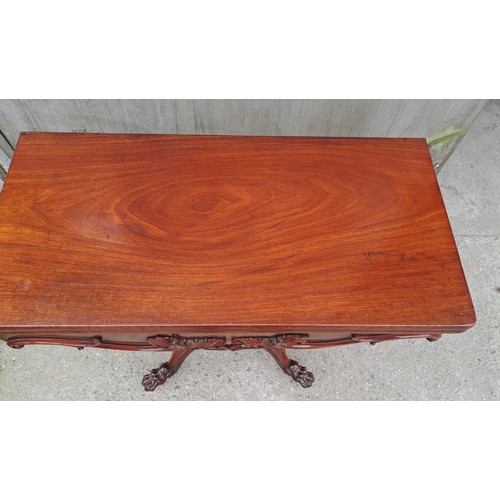 68 - A 19thC mahogany fold over tea table on pedestal base with paw feet on castors. Open 75cm h x 85cm w... 