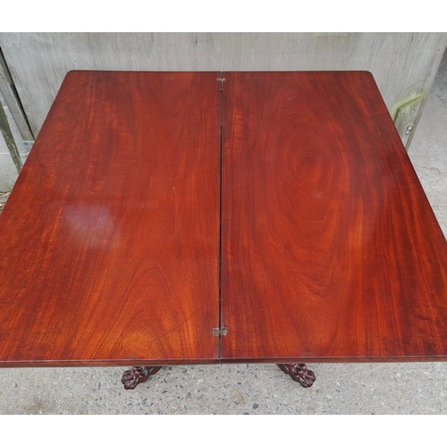 68 - A 19thC mahogany fold over tea table on pedestal base with paw feet on castors. Open 75cm h x 85cm w... 