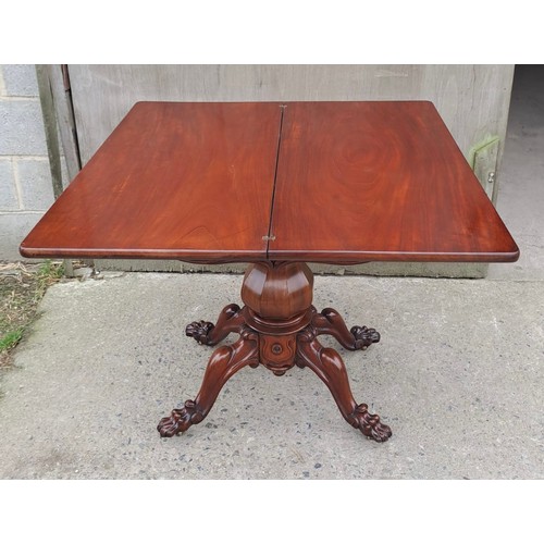 68 - A 19thC mahogany fold over tea table on pedestal base with paw feet on castors. Open 75cm h x 85cm w... 