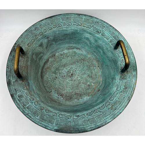 1006 - A twin handled metal bowl with decoration to interior. 40cm d.