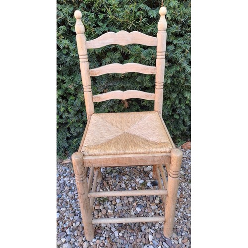 101 - Six rush seated ladder backed dining chairs. 95cm h x 40cm w x 38cm d.