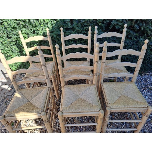 101 - Six rush seated ladder backed dining chairs. 95cm h x 40cm w x 38cm d.