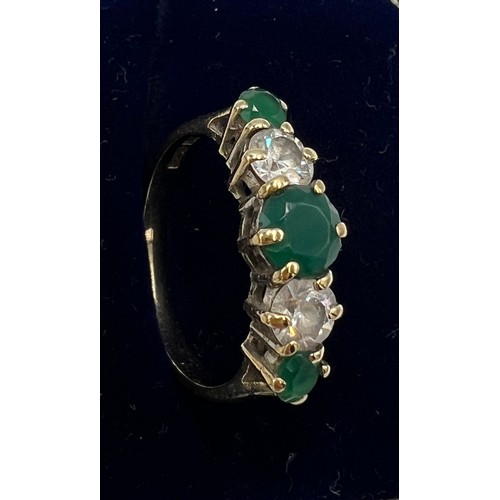 664 - A 9 carat gold ring set with green and clear stones, size O. Weight 2.6gm.