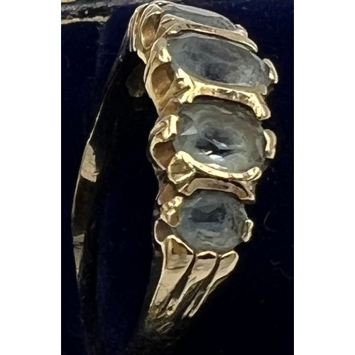 673 - A 9 carat gold ring set with five pale blue stones. Size O. Weight 2.8gm.