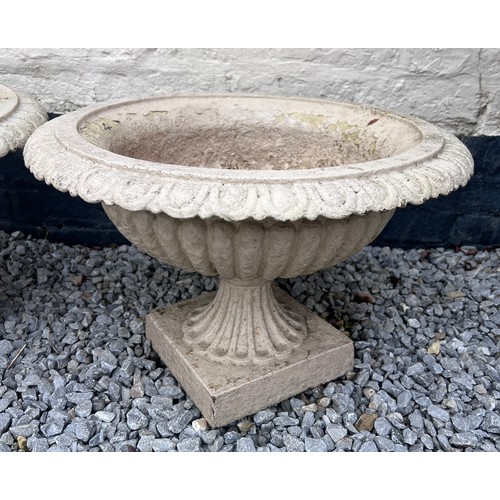 11 - An antique pair of painted cast iron fluted pedestal urns. 55 w x 38cm h.