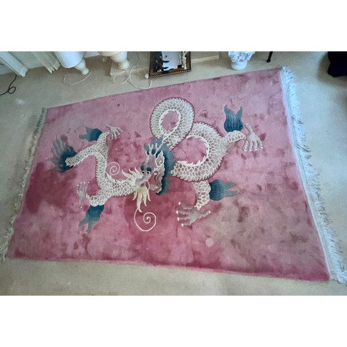 1284 - A 20thC thick Kayam oriental rug with dragon decoration on pink ground. Size without tassels 276cm l... 