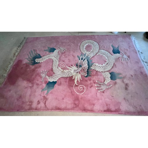 1284 - A 20thC thick Kayam oriental rug with dragon decoration on pink ground. Size without tassels 276cm l... 