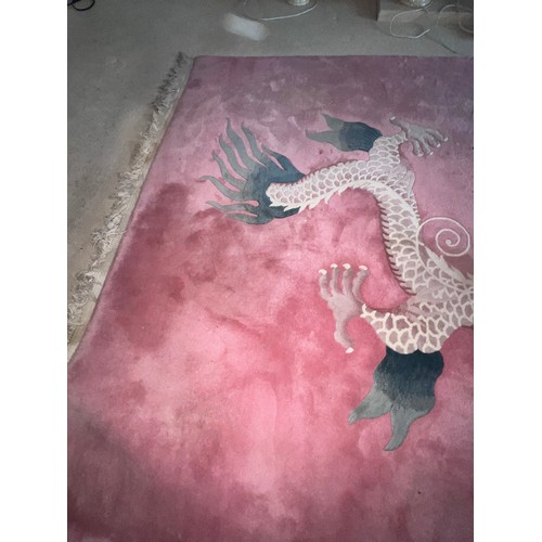 1284 - A 20thC thick Kayam oriental rug with dragon decoration on pink ground. Size without tassels 276cm l... 