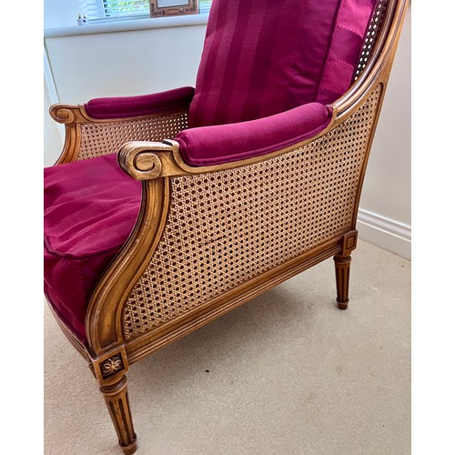 127 - A 20thC bergère armchair. Height to back 91cm x 69.5cmn d x 67cm d.