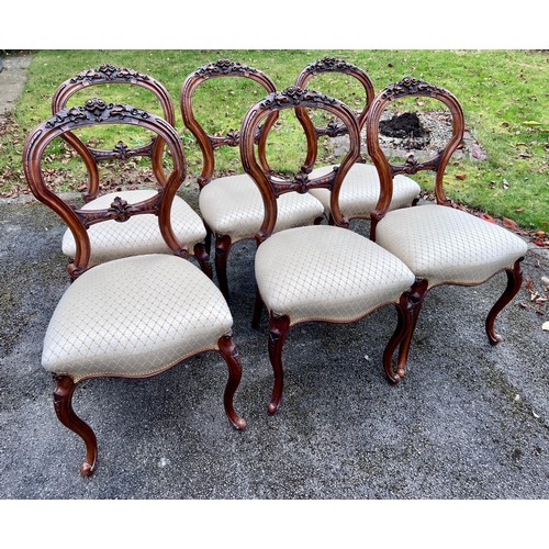 132 - A set of six 19thC walnut balloon backed dining chairs with carved crest rials and cabriole legs. He... 