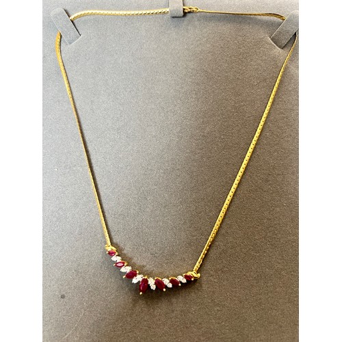 647 - A diamond and ruby necklace on an 18 carat gold chain. Weight 10.3gm. Length 38cm. In original prese... 