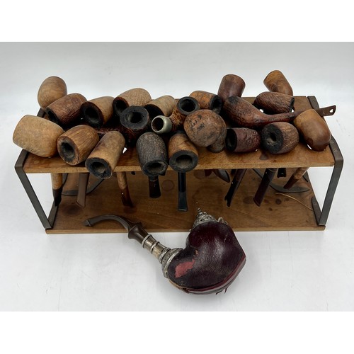 1351 - Wooden pipe rack and various pipes, some with silver mounts, to include a 19thC meerschaum pipe with... 