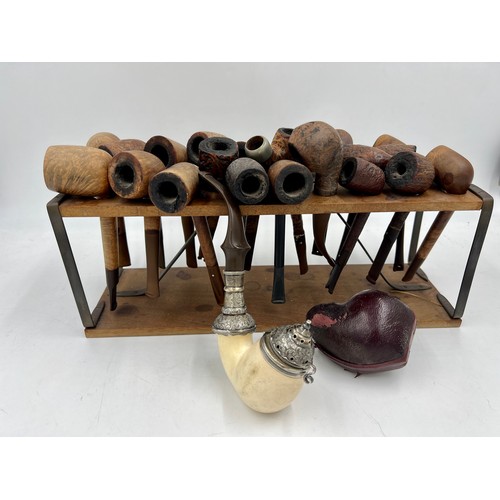 1351 - Wooden pipe rack and various pipes, some with silver mounts, to include a 19thC meerschaum pipe with... 