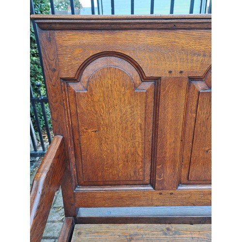 121 - A 19thC oak panel backed settle. 110 h x 184 w x 65cm d.