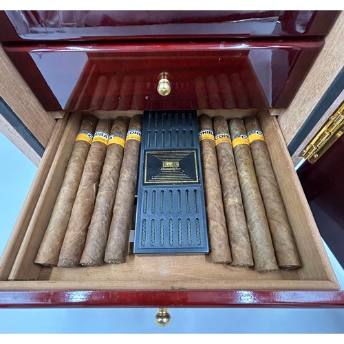 1356 - A lacquered wood humidor cabinet with a glazed door enclosing seven cigar trays and a hygrometer con... 