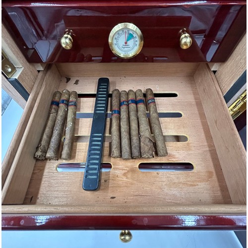 1356 - A lacquered wood humidor cabinet with a glazed door enclosing seven cigar trays and a hygrometer con... 