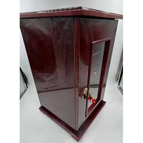 1356 - A lacquered wood humidor cabinet with a glazed door enclosing seven cigar trays and a hygrometer con... 