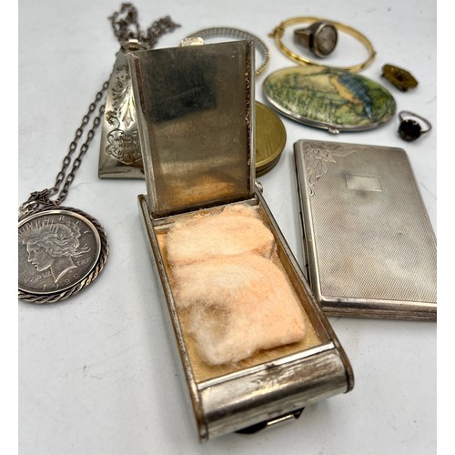 1354 - A miscellany to include vintage compacts, Victorian skirt lift, one dollar pendant, .900 silver ring... 