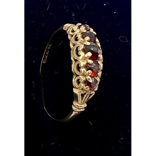 562 - A nine carat gold ring set with red stones. Size L/M. Weight 1.4gm.