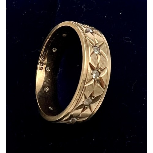 566 - A 9 carat gold band set with clear stones. Size N. Weight 3.8gm.