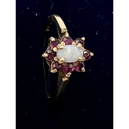 568 - A nine carat gold opal and garnet ring. Size M. Weight 1.8gm.