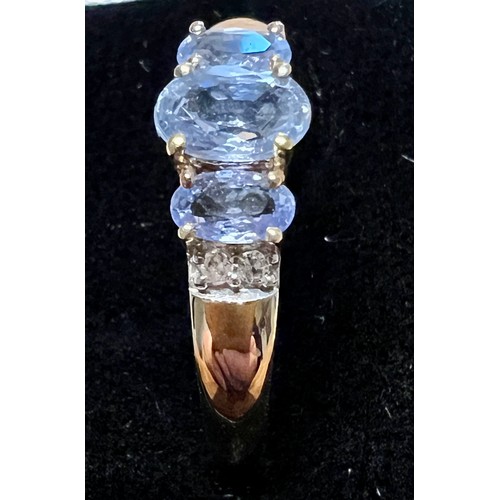 594 - A three stone sapphire and diamond ring set in 9 carat yellow gold, size V, weight 2.2gm.