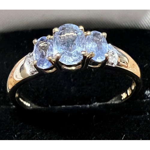 594 - A three stone sapphire and diamond ring set in 9 carat yellow gold, size V, weight 2.2gm.