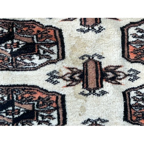 1285 - A cream ground wool carpet. 188 l x 125cm w without tassels.