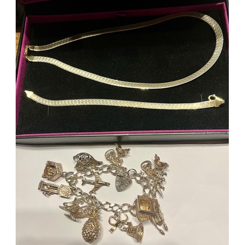 602 - A silver charm bracelet with multiple charms and a gold plated silver matching necklace and bracelet... 