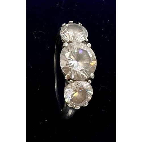 614 - A three stone white sapphire ring set in unmarked white metal, size P/Q. Weight 3.8gm.