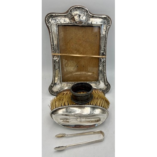 921 - A quantity of hallmarked silver to include photograph frame, napkin ring, tongs and two gentleman's ... 