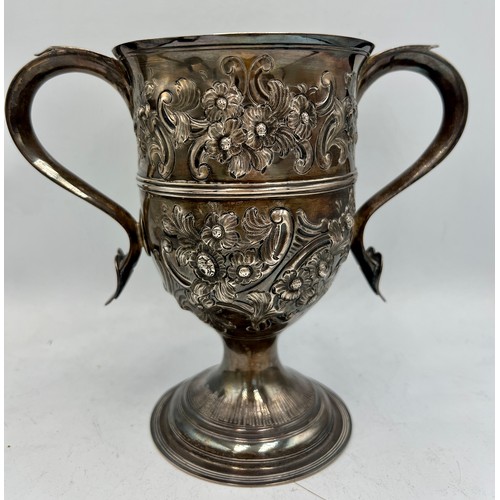 936 - A hallmarked twin handled silver cup with embossed decoration. Later decoration and inscription. Lon... 