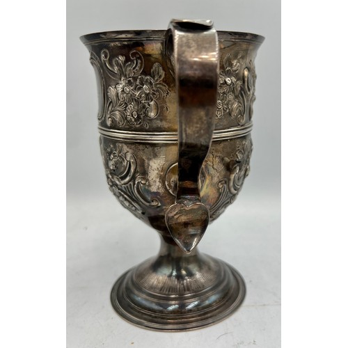 936 - A hallmarked twin handled silver cup with embossed decoration. Later decoration and inscription. Lon... 