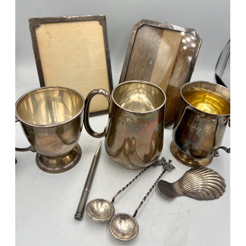 937 - Hallmarked silver to include three mugs, two photograph frames, shell caddy spoon, Mordan Everpoint ... 