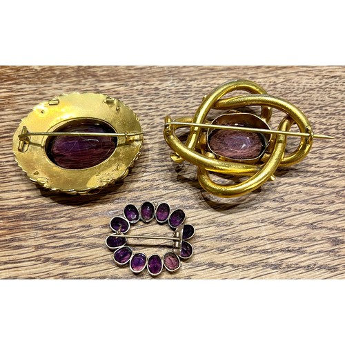 585 - Three 19thC brooches set with purple stones. Largest 5cm x 4cm.