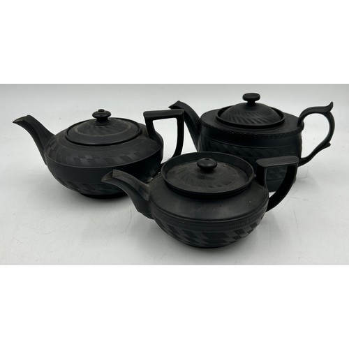 224 - A group of early 19th century black basalt engine turned teapots and covers, one with dog finial c. ... 