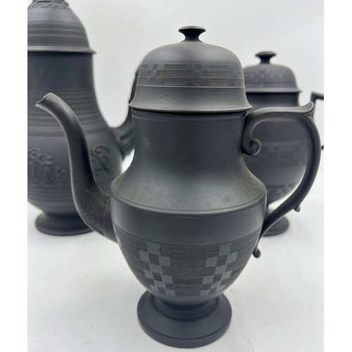 244 - A group of early 19th century black basalt coffee pots and covers, c. 1810. Some are engine turned, ... 