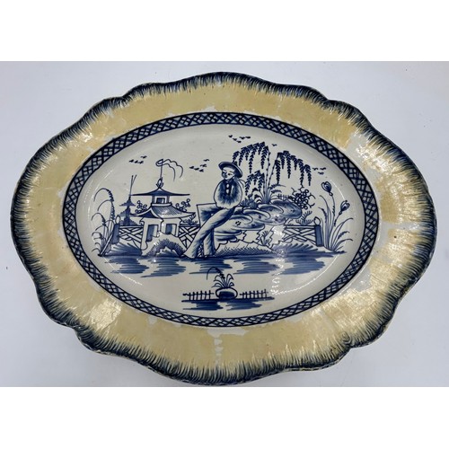 306 - Two early 19th century blue and white hand-painted, shell edge platters, one with a Chinese figure, ... 