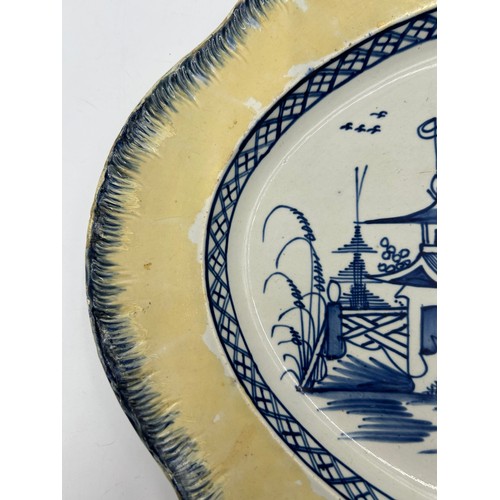 306 - Two early 19th century blue and white hand-painted, shell edge platters, one with a Chinese figure, ... 