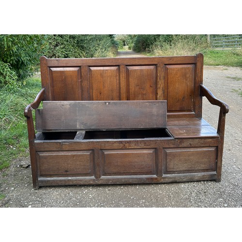 15 - A 18th/19thC oak settle with panelled back and front and lift up seats. 102 h x 152 w x 54cm d appro... 