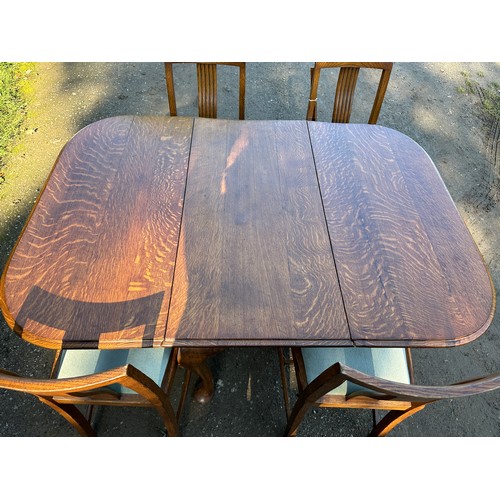 157 - An oak drop leaf table on cabriole legs together with four chairs. 107 w x 150 l (extended) x 74cm h... 