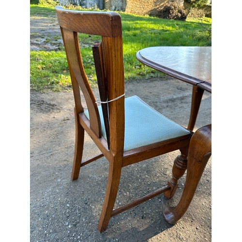 157 - An oak drop leaf table on cabriole legs together with four chairs. 107 w x 150 l (extended) x 74cm h... 